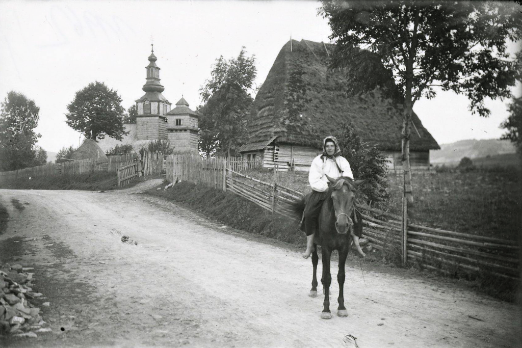 Жінка на коні біля церкви у селі Ізки на Міжгірщині, 1921 р. Amalie Kožmínová, Fotoarchiv Československé tiskové kanceláře, Praha.png