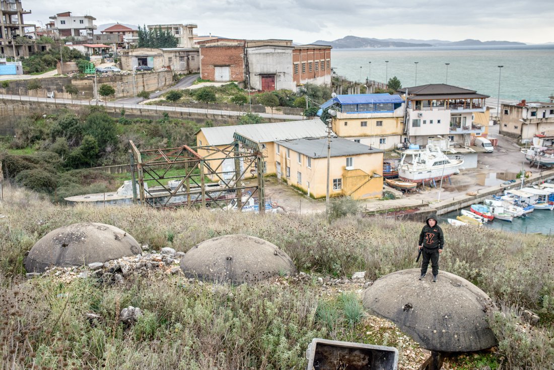 Хлопчик з іграшковим пістолетом стоїть на бункері біля порту, Саранда, Албанія